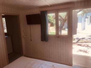 a room with a window and a flat screen tv at Barreira Beachfront Rooms 6 in Kalamata