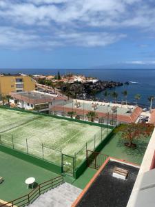 a tennis court with the ocean in the background at Tagara in Puerto de Santiago