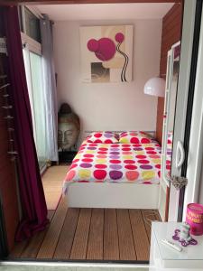 - une chambre avec un lit et une couette colorée dans l'établissement Le Neptune, à Contis-les-Bains