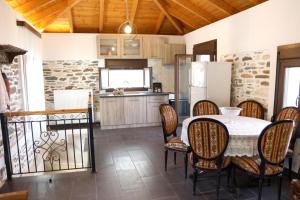 a kitchen and dining room with a table and chairs at Archontiko Nikolaou Keramidi in Keramídhion