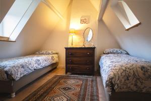 a attic bedroom with two beds and a mirror at Authentique Maison familiale en Périgord Pourpre in Lembras