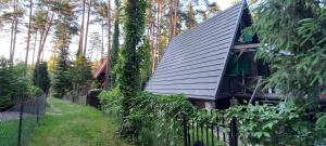 ein Haus mit einem Metalldach und einem Zaun in der Unterkunft Domek letniskowy nad jeziorem, Mazury in Teerau