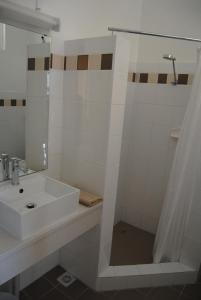 a bathroom with a shower, sink, and mirror at Airlie House Motor Inn in Scone