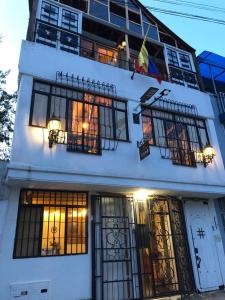 Amuya Hostel في Chiquinquirá: مبنى أبيض مع الكثير من النوافذ