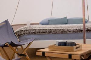 シャンパニャック・デ・ベルエアーにあるBelair le Campingのベッドルーム1室(ベッド1台、青い椅子付)