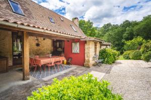 a red house with a table in front of it at Authentique Maison familiale en Périgord Pourpre in Lembras