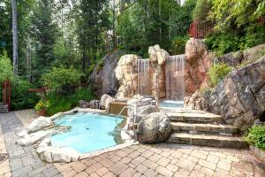a small pool with a waterfall in a backyard at Tremblant Prestige - Les Eaux 227-6 in Mont-Tremblant