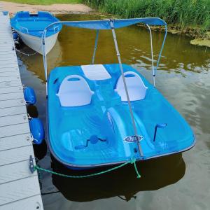 a blue boat tied to a dock in the water at Przystań Nad Miążką in Sapowice +35 photos