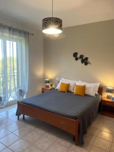a bedroom with a large bed with yellow pillows at villa Giò in Racalmuto