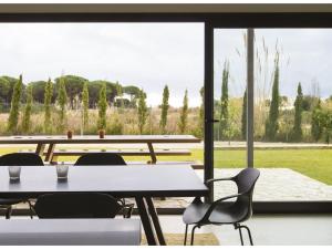 une pièce avec des tables et des chaises et une grande fenêtre dans l'établissement Elegant Villa by the Coast, à Sant Andreu de Llavaneres