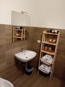 a bathroom with a sink and a shelf with towels at B&B il Santo in Castelleone di Suasa +20 photos