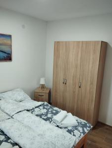 una camera da letto con un letto e un armadio in legno di Apartman Bojković a Soko Banja