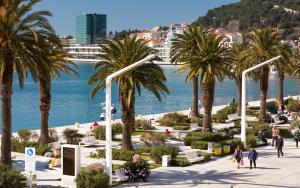a view of a beach with palm trees and the water at Litore Luxury Rooms JUGO in Split