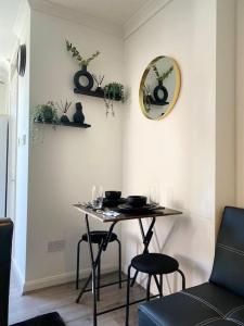 a table and two chairs in a room with a mirror at Compact contemporary modern studio in Stivichall