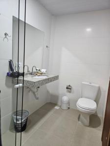 uma casa de banho branca com um WC e um lavatório em Pousada Villa Encantada Ilha do Mel na Ilha do Mel
