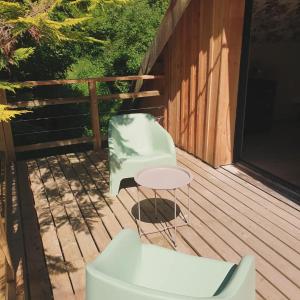 a chair and a table on a deck at Chambres d'Hôtes du Domaine de Bourbacoup in Tulle