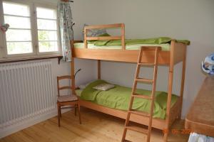 - une chambre avec 2 lits superposés et une chaise dans l'établissement Landhaus Ottenberg, à Kressbronn am Bodensee