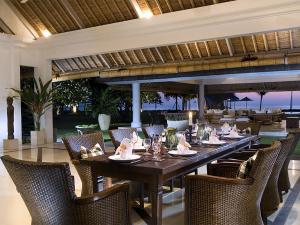 Villa Atas Ombak في سمينياك: غرفة طعام مع طاولة وكراسي طويلة