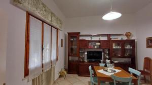 a dining room with a table with chairs and a television at casa vacanze Luisa in Lazzeretto