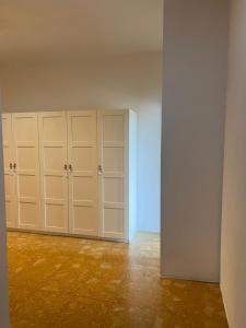an empty room with white cabinets and a wall at mirabello in Reggio Emilia