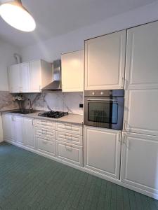 a kitchen with white cabinets and a microwave at mirabello in Reggio Emilia