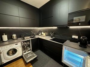 a kitchen with a washing machine and a washer at BASTINAZO ALOHADREAM - EXCLUSIVO - Design Suite Luxury Love and Spa - Jacuzzi y Sauna Privados in El Puerto de Santa María