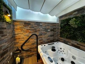 a jacuzzi tub in a room with bricks at BASTINAZO ALOHADREAM - EXCLUSIVO - Design Suite Luxury Love and Spa - Jacuzzi y Sauna Privados in El Puerto de Santa María +23 photos