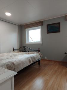 a bedroom with a bed and a window at Sveciu namai in Vikedal