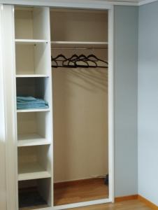 a walk in closet with white shelves at Sveciu namai in Vikedal +9 photos