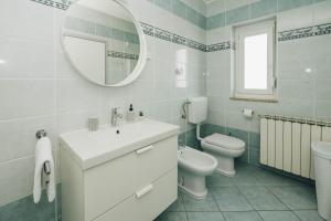 ein Badezimmer mit Waschbecken, Toilette und Spiegel in der Unterkunft Villa Luna in Poreč + 29 Fotos