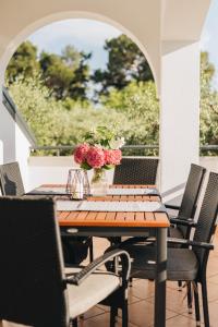 einen Holztisch mit Blumenvasen auf einer Terrasse in der Unterkunft Villa Luna in Poreč