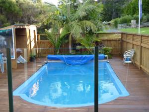 ein großer Pool mit Sonnenschirm im Hinterhof in der Unterkunft Waikare Cove in Russell