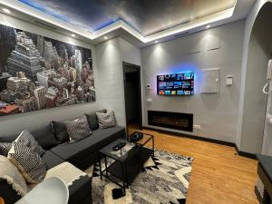 a living room with a couch and a tv at BASTINAZO ALOHADREAM - EXCLUSIVO - Design Suite Luxury Love and Spa - Jacuzzi y Sauna Privados in El Puerto de Santa María