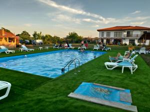 a pool with chairs and a slide in a yard at Paradiso Resort in Sarinasuf