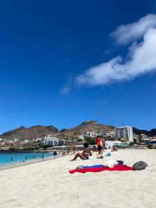 un gruppo di persone sdraiate su una spiaggia di Muralha Rooms a Mindelo