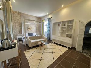 a living room with a bed and a couch and a table at Riad SABIDI in Essaouira