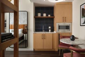 a kitchen with wooden cabinets and a table in a room at Burton House, Beverly Hills, A Tribute Portfolio Hotel in Los Angeles