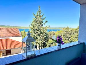 a vase of flowers on a balcony with a tree at Romantic 3 Bedroom Apartment 3min from the beach in Kruševo