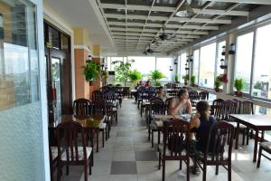 a group of people sitting at tables in a restaurant at Hau Giang Hotel in Can Tho