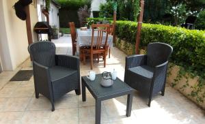 a patio with a table and chairs and a table and chairs at Valérie GOUFFÉ Chambres d'hotes in Parigné-lʼÉvêque
