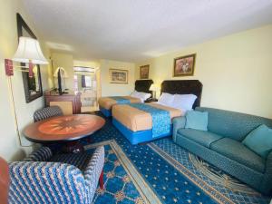 a hotel room with a bed and a couch at Maple Leaf Inn & Suites in Kissimmee