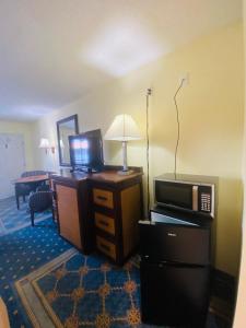 a hotel room with a television and a microwave at Maple Leaf Inn & Suites in Kissimmee