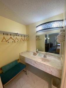 a bathroom with a sink and a mirror at Maple Leaf Inn & Suites in Kissimmee