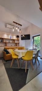 sala de estar con mesa de comedor y sillas amarillas en Domek Augustówka, en Świeradów-Zdrój
