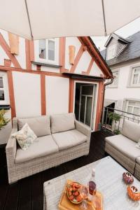 balcón con sofá y mesa con comida. en Modernes Tiny House mit Sonnenterrasse, en Ediger-Eller