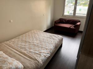 a bedroom with a bed and a chair and a window at Odivelas Inn in Odivelas +1 photo