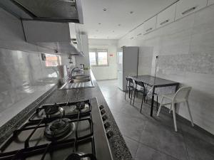 a kitchen with a stove and a table with chairs at Odivelas Inn in Odivelas