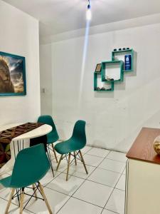 a room with chairs and a table and a counter at Apartamento aconchegante in Petrolina