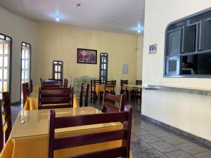 a dining room with tables and chairs in a restaurant at Guará Praia Hotel in Salinópolis