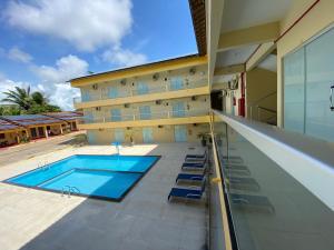 a swimming pool in front of a building at Guará Praia Hotel in Salinópolis